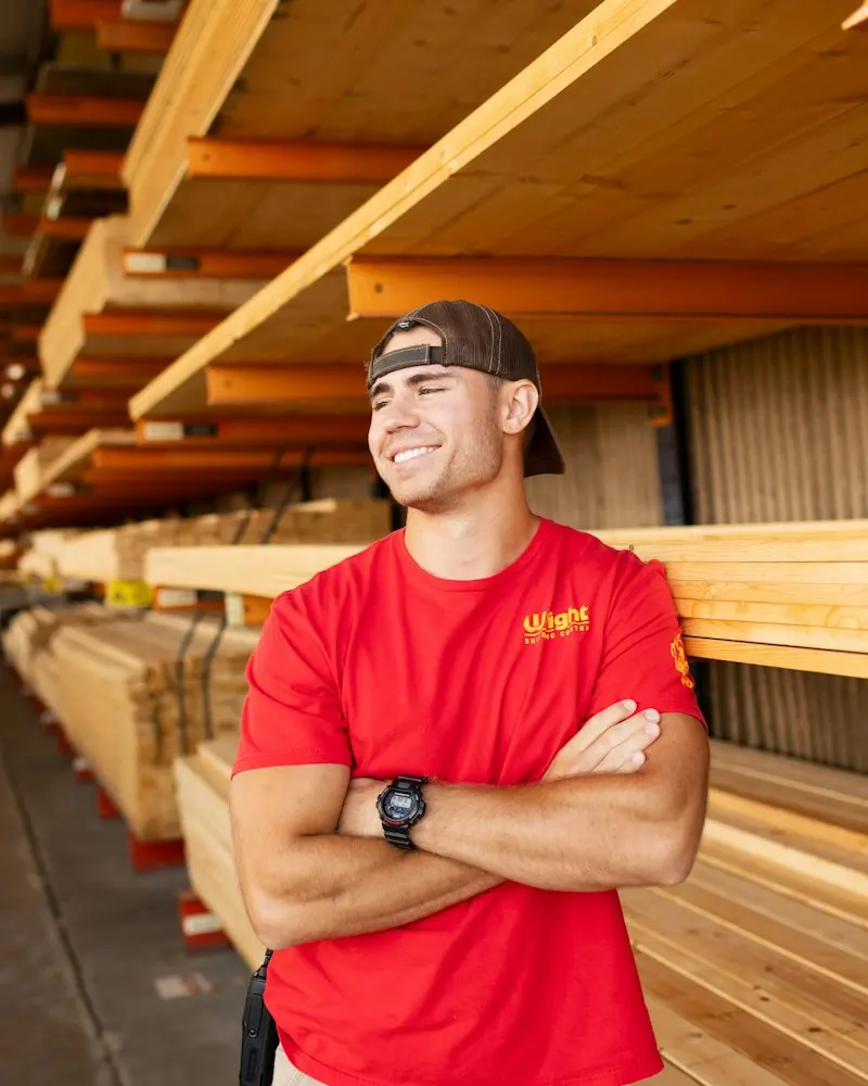 Trabajador de una empresa de servicios sonriendo con los brazos cruzados en su bodega